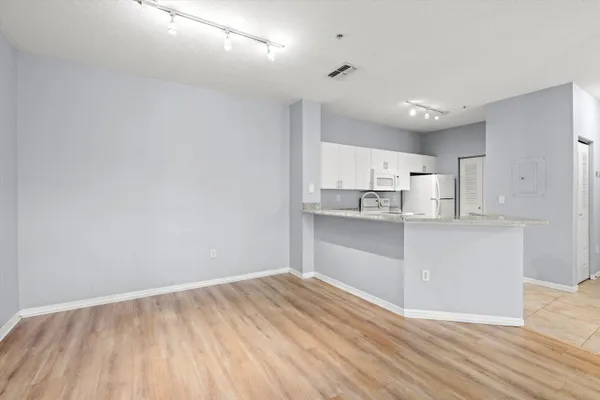 a kitchen with granite countertop white cabinets and wooden floor