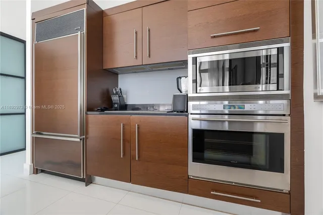 a kitchen with granite countertop white cabinets and stainless steel appliances