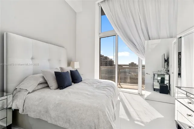 a bedroom with a large bed and a large window