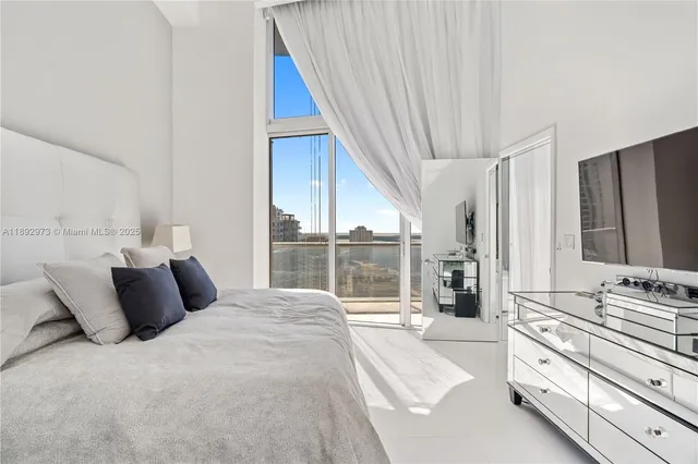 a bedroom with a bed and a large window