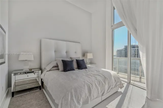 a bedroom with a bed and a large window