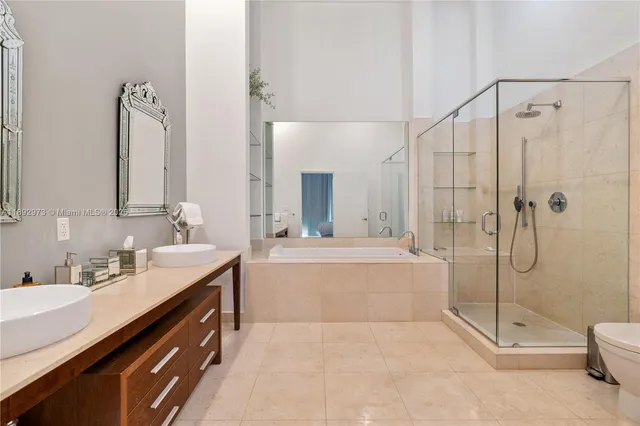 a bathroom with a tub sink shower and mirror