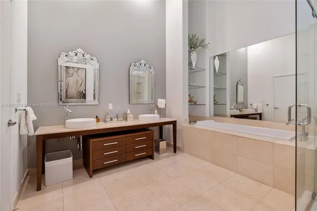 a spacious bathroom with a double vanity sink mirror and bathtub