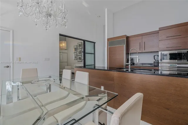 a living room with couches and kitchen view with wooden floor