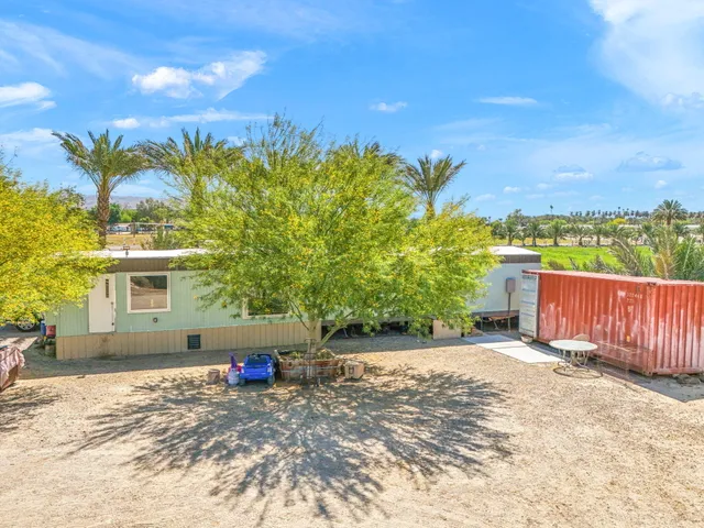 a view of a house with backyard and sitting area