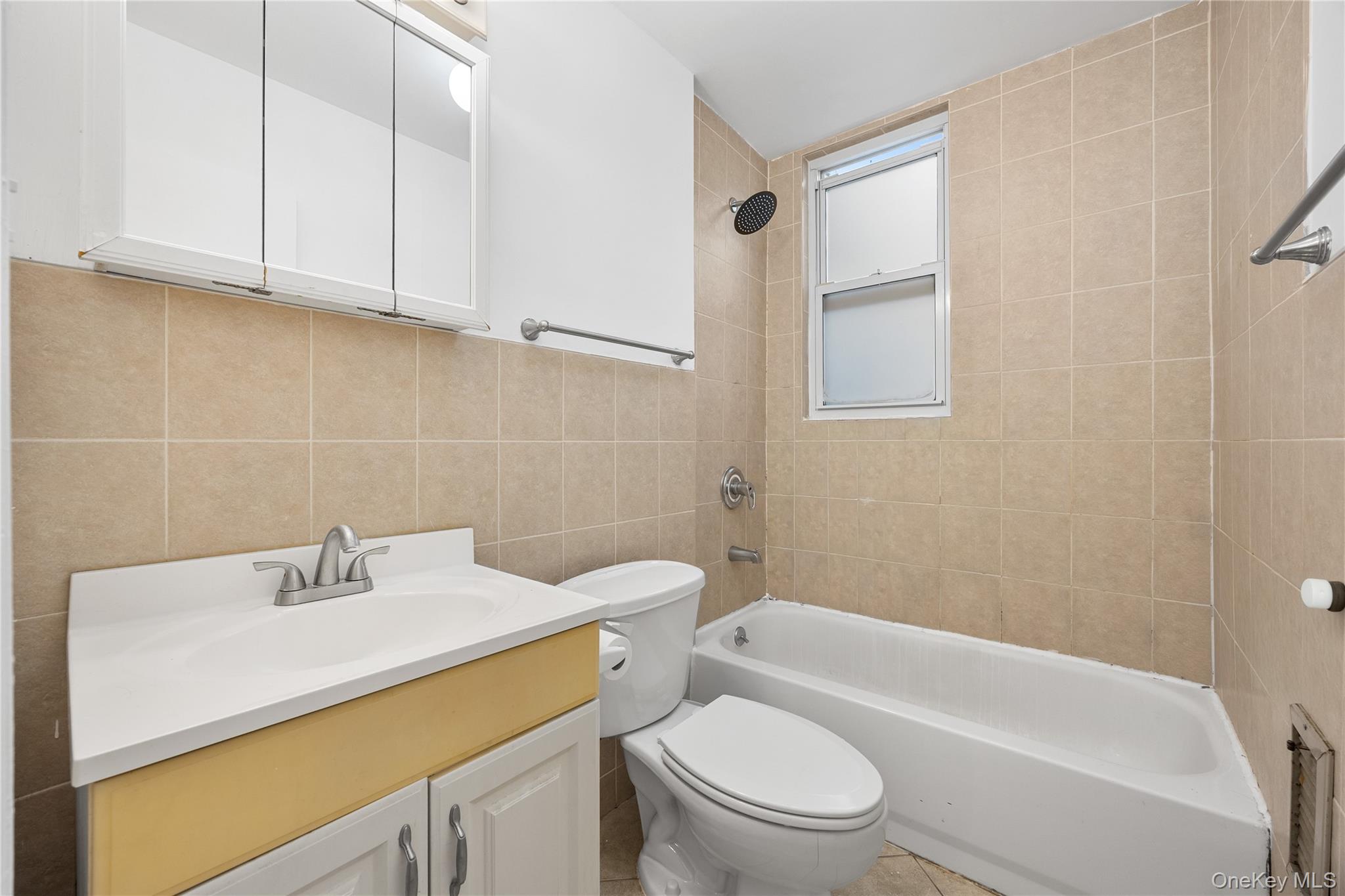 71-11 68th Street Queens, NY 11385 - Photo 8 of 24 Bathroom with vanity, tile walls, and shower / bathtub combination
