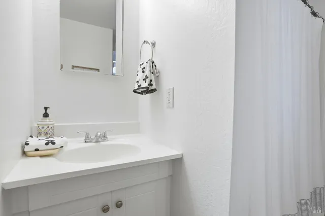 a bathroom with a granite countertop toilet and a shower