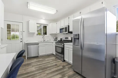 a kitchen with stainless steel appliances granite countertop a sink dishwasher a stove microwave and oven with cabinets