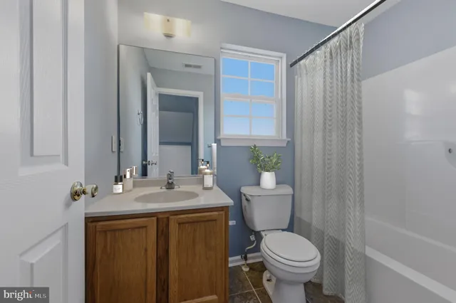 a bathroom with a granite countertop toilet sink and mirror