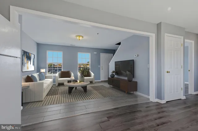 a living room with furniture flat screen tv and wooden floor