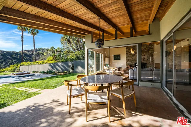 a view of swimming pool with outdoor seating and a patio