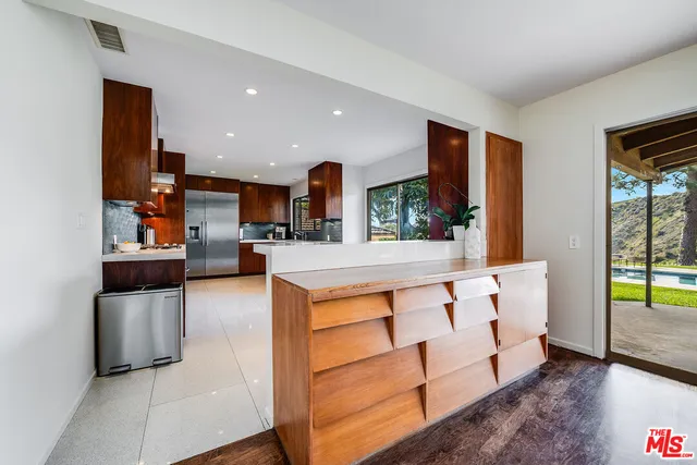 a kitchen with stainless steel appliances kitchen island sink refrigerator and stove