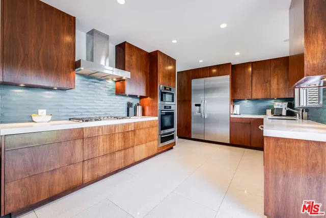 a kitchen with stainless steel appliances wooden cabinets a sink and a counter top space