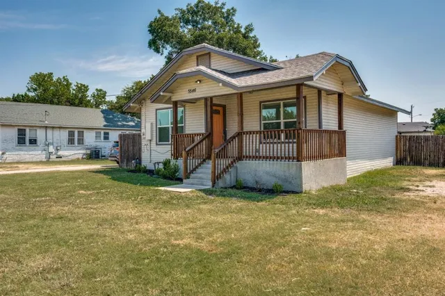 a view of a house with a yard and potted plants