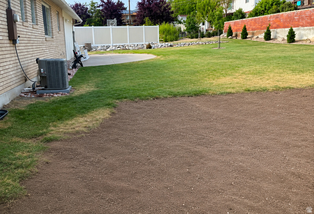 1020 Wilmar Place Centerville, UT 84014 - Photo 22 of 22 Spacious outdoor area with a large prepared soil bed, an adjacent green lawn, and a curved concrete patio