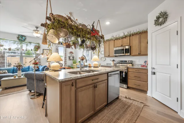 a kitchen with kitchen island granite countertop a sink appliances cabinets and furniture