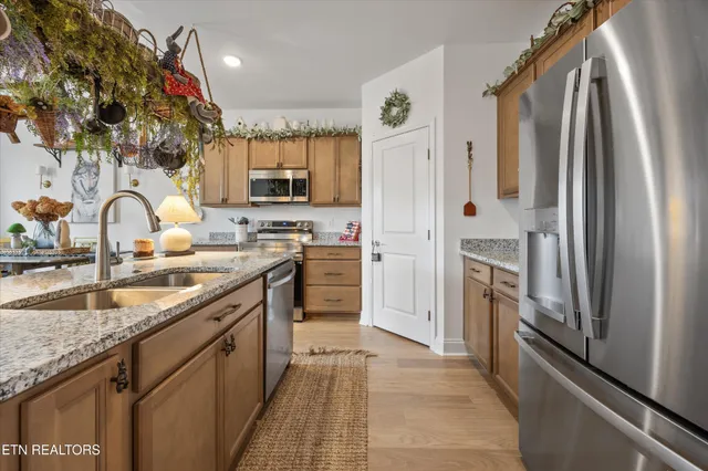 a kitchen with stainless steel appliances granite countertop a refrigerator a sink a stove and island