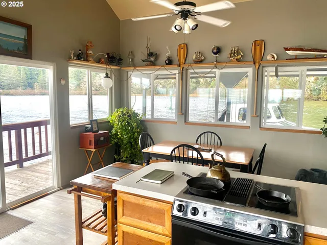 a kitchen with a stove a refrigerator and a dining table with wooden floor