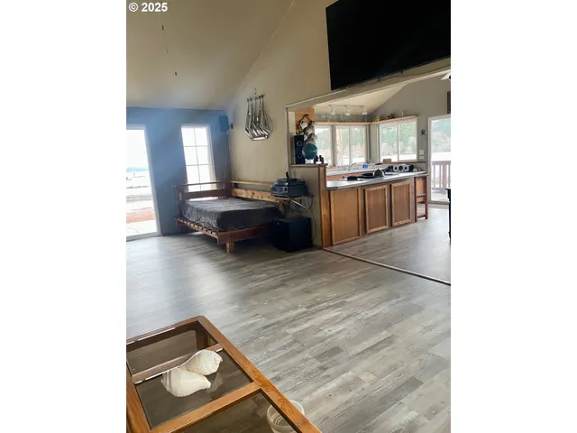 a living room with couches and kitchen view with wooden floor