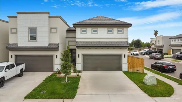 a front view of a house with a garden and garage