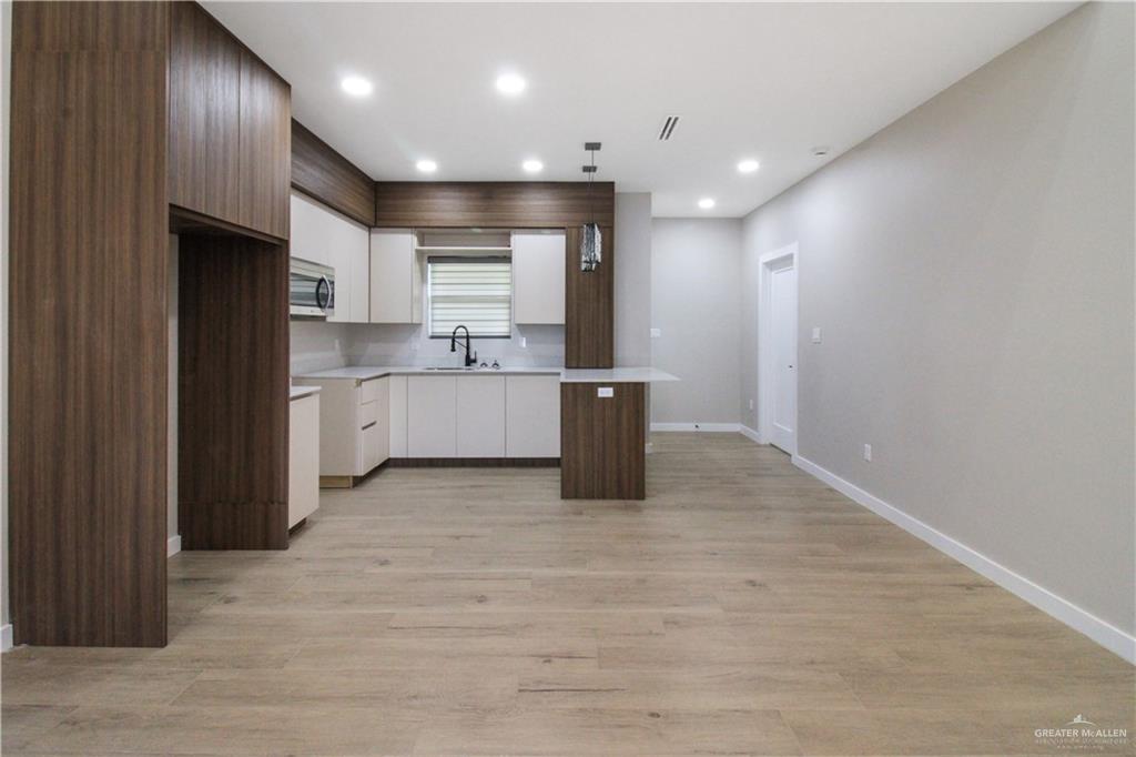 2202 Corales Street Mission, TX 78573 - Photo 2 of 18 Kitchen featuring a center island, light countertops, modern cabinets, recessed lighting, and light wood-style floors. Stainless steel appliances will be included