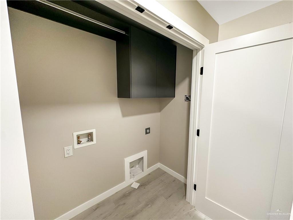 2202 Corales Street Mission, TX 78573 - Photo 3 of 18 Laundry area featuring hookup for a washing machine, light wood-style floors, and electric dryer hookup
