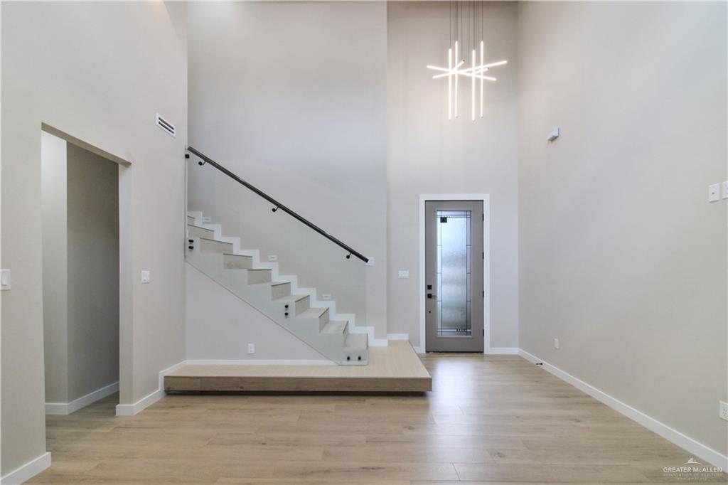 2202 Corales Street Mission, TX 78573 - Photo 9 of 18 Foyer featuring light wood-type flooring, a high ceiling, and hanging lights