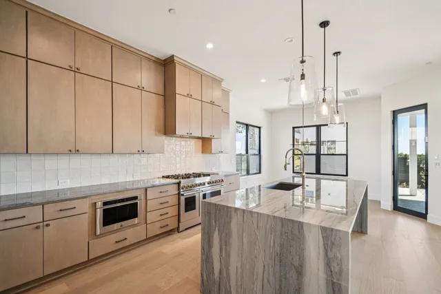 a kitchen with stainless steel appliances kitchen island wooden floors and white cabinets