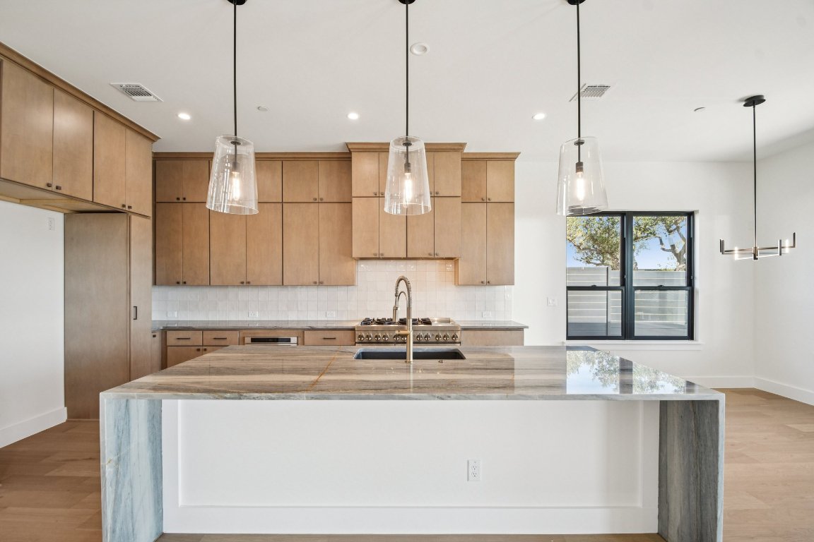 5903 Moondust Lane Austin, TX 78730 - Photo 14 of 37 a kitchen with kitchen island a counter top space a sink a window and stainless steel appliances