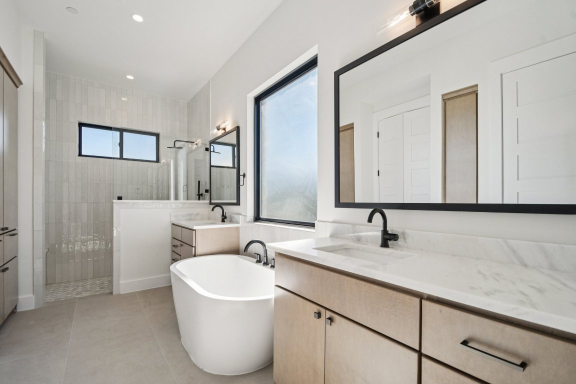 5903 Moondust Lane Austin, TX 78730 - Photo 18 of 37 a bathroom with a double vanity sink a mirror and a