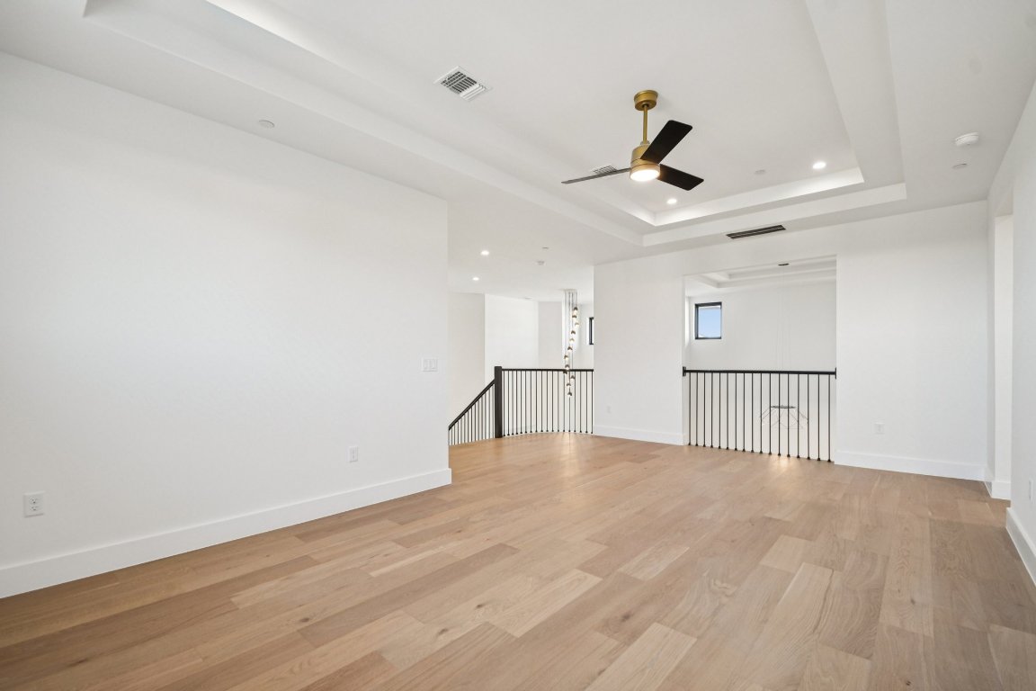 5903 Moondust Lane Austin, TX 78730 - Photo 23 of 37 a view of an empty room with wooden floor and a ceiling fan
