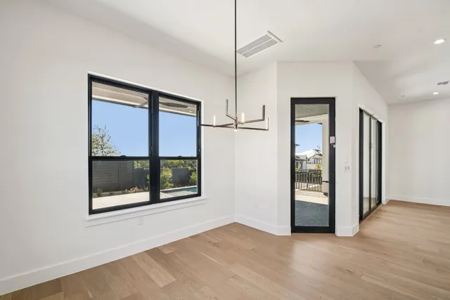 a view of an empty room with glass door and a window