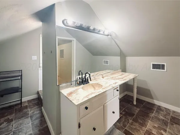 a spacious bathroom with a granite countertop sink and a mirror