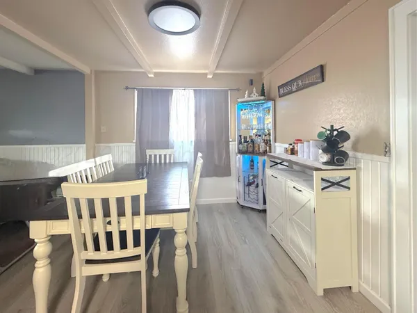 a view of a dining room and livingroom with furniture wooden floor a chandelier