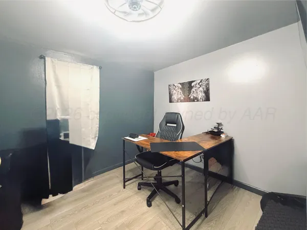 a view of a workspace with furniture and wooden floor