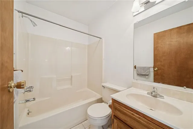 a spacious bathroom with a toilet a sink and a mirror