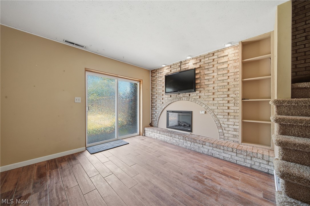 824 South Chillicothe Road, Unit 2 Aurora, OH 44202 - Photo 33 of 42 Brick-accented wall featuring a built-in fireplace, recessed lighting, and integrated shelving. (lower level)