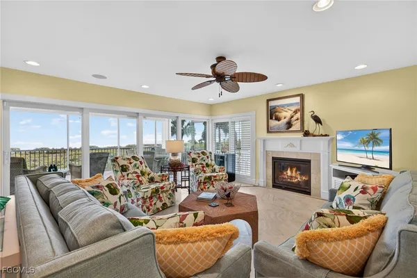 a living room with furniture a fireplace and a floor to ceiling window