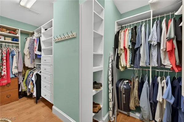 a view of walk in closet with clothes and shoes