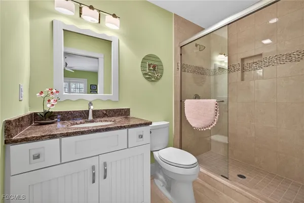 a bathroom with a granite countertop sink a toilet and a mirror