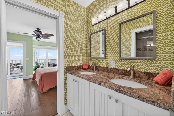 a bathroom with a granite countertop sink a mirror and a bathtub