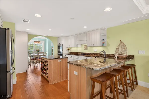 a view of a dining room with furniture a kitchen and chandelier