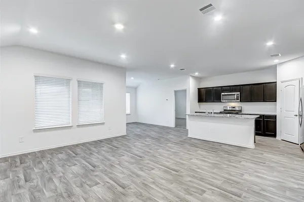 a large kitchen with stainless steel appliances kitchen island a large counter top and a stove top oven