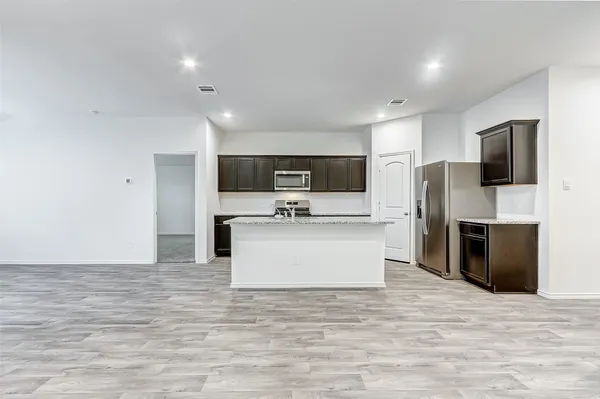 a view of kitchen with microwave oven stove and refrigerator