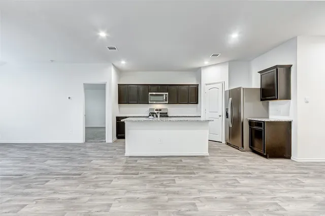 a view of kitchen with microwave oven stove and refrigerator