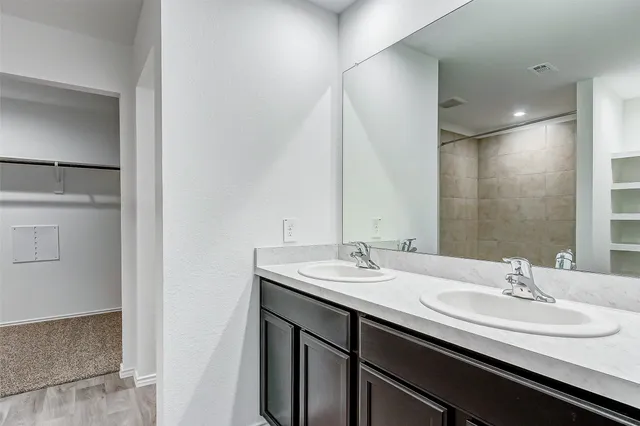 a bathroom with a double vanity sink and a mirror