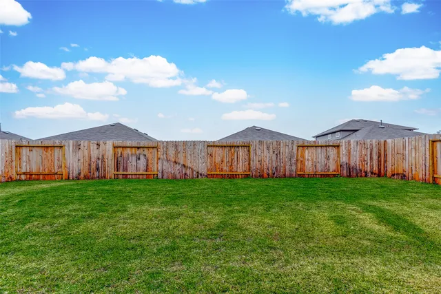 a view of a yard with wooden fence