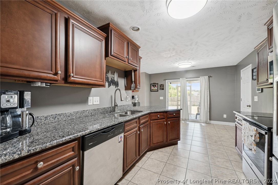 176 Vandercroft Way Bunnlevel, NC 28323 - Photo 11 of 36 a kitchen with stainless steel appliances granite countertop a sink stove and cabinets