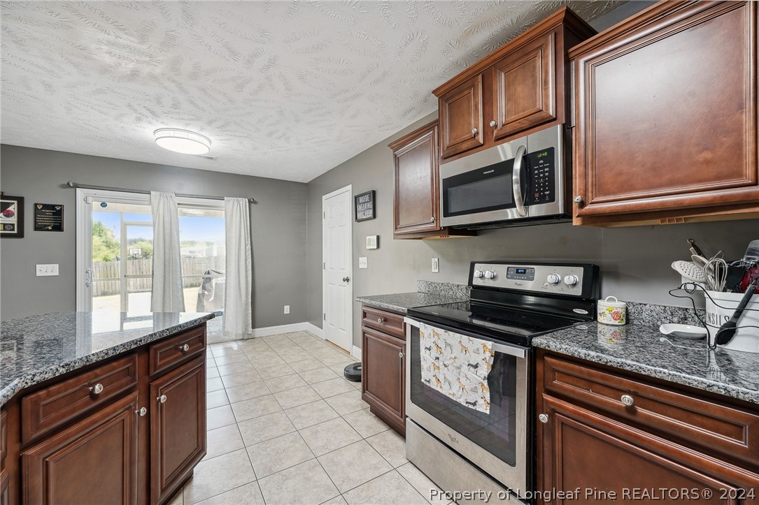 176 Vandercroft Way Bunnlevel, NC 28323 - Photo 12 of 36 a kitchen with stainless steel appliances granite countertop a stove and a microwave