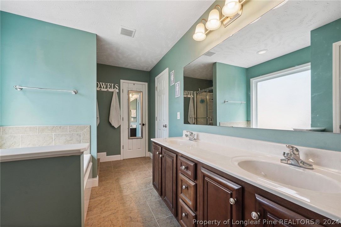 176 Vandercroft Way Bunnlevel, NC 28323 - Photo 21 of 36 a spacious bathroom with double vanity and a mirror